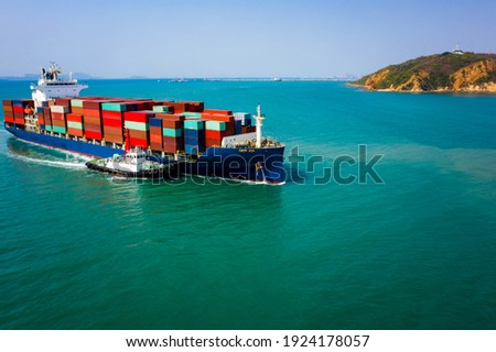 Container ship transporting large cargo logistic to import export goods internationally around the world, including Asia Pacific and Europe, by deep sea blue sky island background Aerial view photo