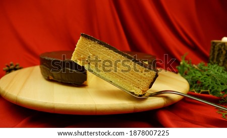A slice of traditional German Christmas Cake Baumkuchen, Schichtkuchen on a red background Stock foto © 