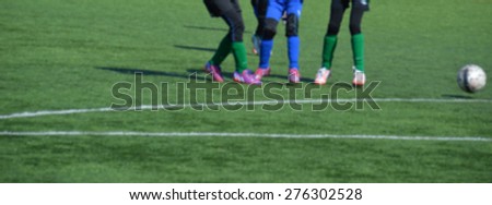 Soccer concept - young female players on turf field with a ball - blurred image, use for example as banner
