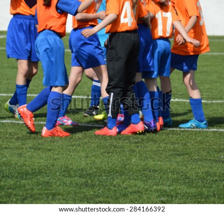 Young female soccer player team congratulating each other. Group of soccer girls happy about achievement and victory. European football team of young women. Blurred image.