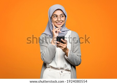 Beautiful Asian woman smiling and holding smartphone
