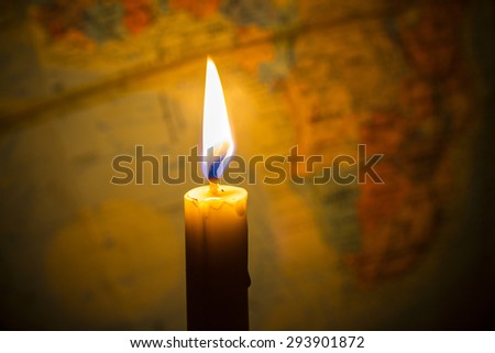 Candle light with  bur world globe  as a  background, copy space