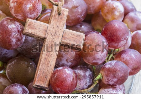 Wooden cross and grape on wooden background, christian symbol Jesus is the true vine from bible verses John 15:1