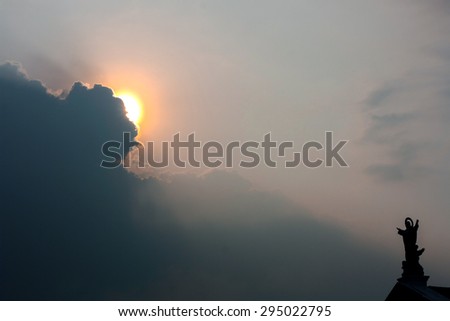 Shadow statue of Jesus on the roof of the church and God\'s light through the clouds in natural light on evening .
