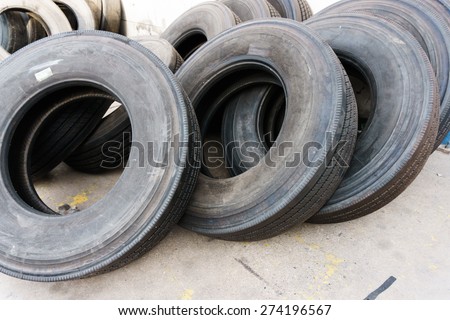 Tires stacked on cement ground, used car tires