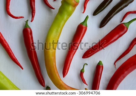 Colorful spicy peppers on white fabric.
