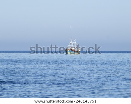 Fishing cutter in front of clear blue sky near Slea Head, Dingle Peninsula, Ireland