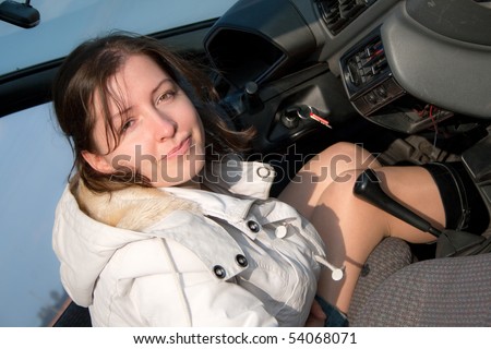 Adult woman in mini skirt sitting on the driver\'s seat