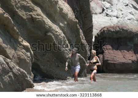 Paros, Greece, 09 August 2015. Couple at Kalogeros beach taking a healing mud bath with clay.