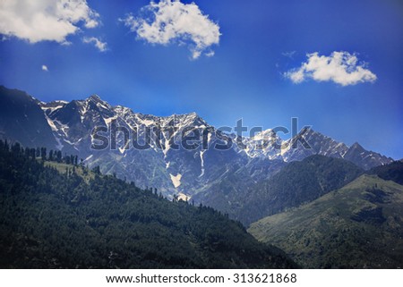 Landscape of the lower section of the Himalayan mountains in India, Kullu valley, Himachal Pradesh  with the lush green forests in front