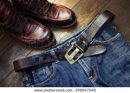 Jeans belt and shoes set on wooden board
