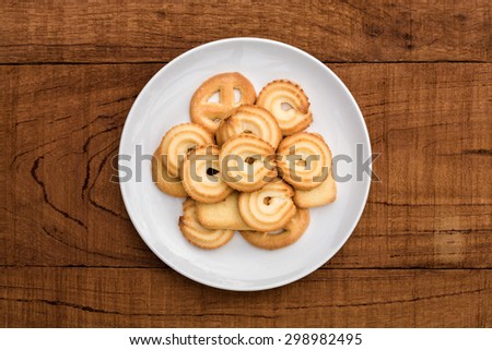 Danish butter Cookies in white ceramic dish on wood board