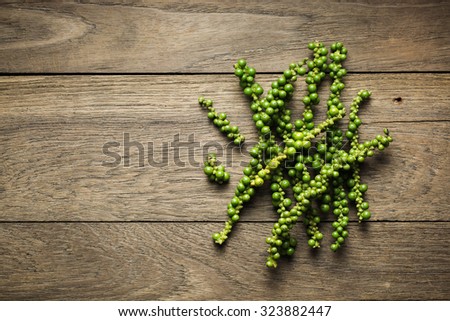 Green peppercorns on rustic wood background, Dark mood of food photography with green peppercorns, Still life photography with overhead view with green peppercorn