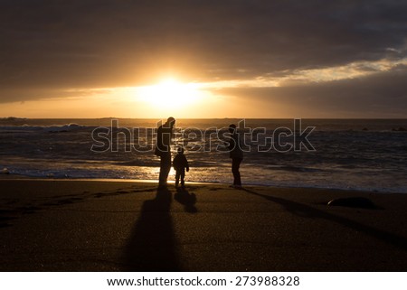 family silhouette - father , mother , child at beach / sunset