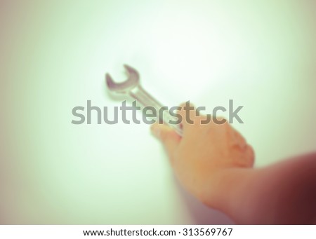 Blur background of old vintage retro used open-end wrenches with hand on background