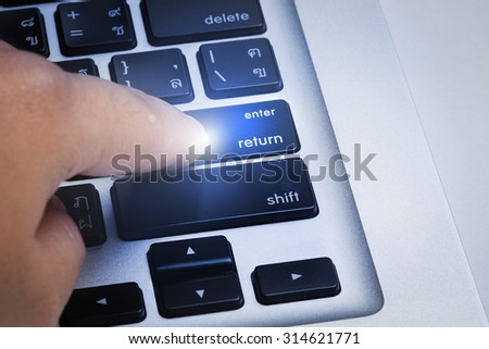 Close up hands with laptop and focus on enter button (English - Thai language)