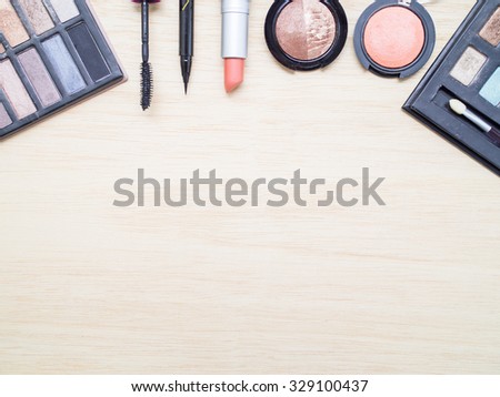 Woman cosmetics - eyeshadow, brush on, lipstick, eye liner, mascara. Top view with space for text.