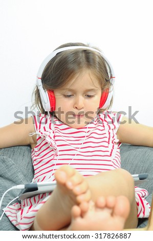 Little girl listening to music indoor.