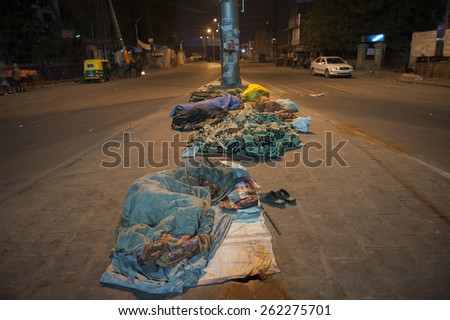 DELHI, INDIA - January 02 15: There are unidentified Indian men sleeping on the street in Delhi in the winter. There are specially many homeless and poor people in the Indian cities.