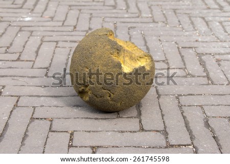 Cracked Moss Rock Ball on Patterned Brick Floor