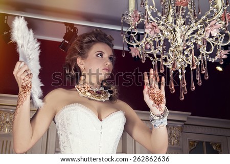 The lady with a tattoo of henna and a beautiful chandelier