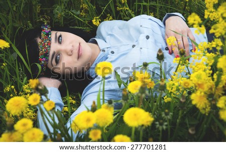 The girl lies in flowers in summer day, the sun shines and birds sing,treatment in the flowers