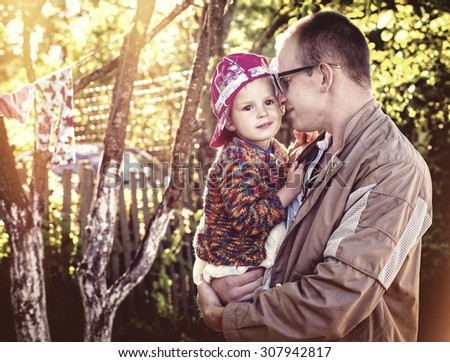 The father and the little daughter outdoors, the father brings up the child