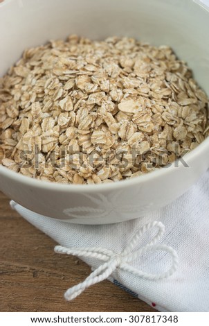 Oats in a white bowl.Close up of porridge oats as background or texture. Diet and healthy nutrition