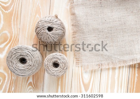 three skeins of jute yarn with sackcloth on wooden table. top view. copy space