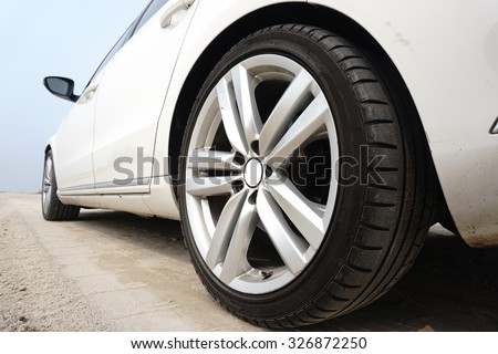 Close up of a black car tyre park on the sand