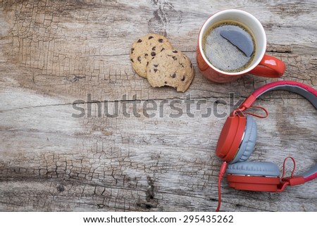 Red coffee cup, Red headphone and chocolate chip cookies on the wooden table. View from above. Coffee with chirstmas concept.