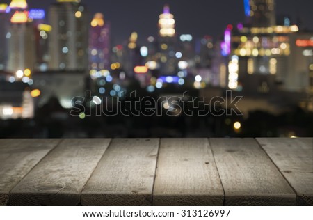 Wood floor with blurred abstract background of city night lights downtown city view : Wooden table with blur background of cityscape