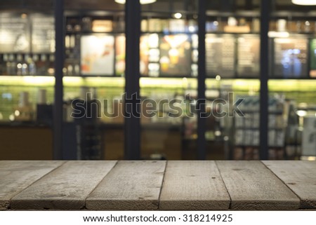 Wood table or floor with blur coffee cafe shop restaurant bokeh background.