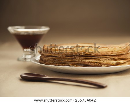 Russian pancakes with wooden spoon and honey on table. Russian cuisine. Taste pancake. Blini. Maslenitsa. Pancake week. Butter Week. Cheesefare Week. Baking
