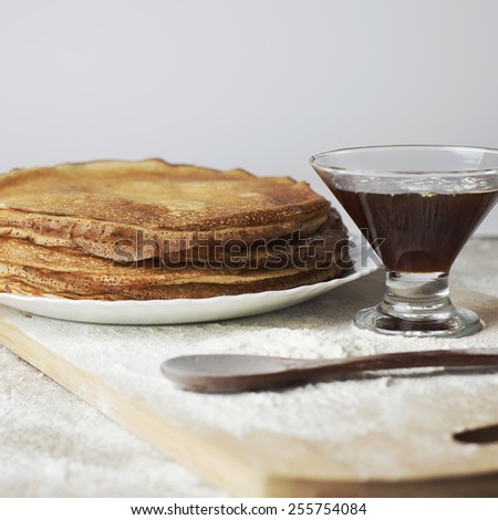 Baking. Russian pancakes with wooden spoon and honey on table. Russian cuisine. Taste pancake. Blini. Pancake week. Butter Week.