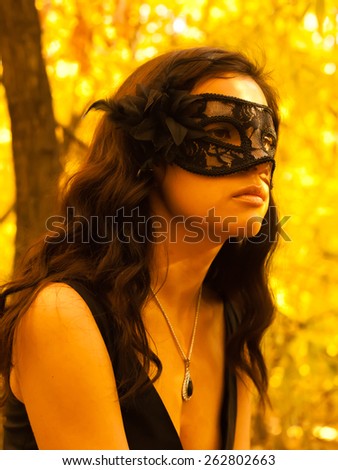 Mask on young woman. Black mask lady. Brunette girl. Autumn face. Masquerade mask