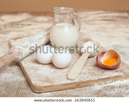 Eggs, milk and spoon of flour. Still life