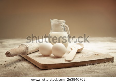 Eggs, milk and spoon of flour. Still life
