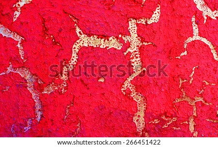Color shriveled, peeling paint on wall - background texture. Red paint peeling off.