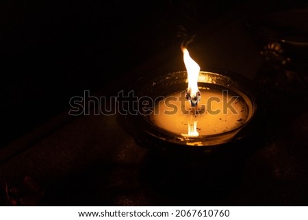 Flame of a candle on a grave. All Saints day. Votive candle on a dark background. All Saints Day 1st November. All Souls Day 2nd November. The Day of The Dead.