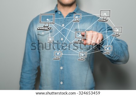 Young man pointing a virtual network on a touchscreen, with a gray background