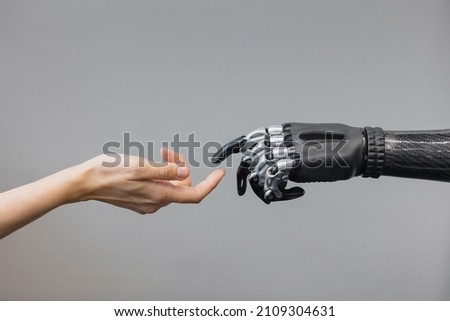 the human hand and the siber hand bionic prosthesis make a handshake and greeting. modern technologies of prosthetics of limbs of hands and feet. full life of people with amputated limbs. black bionic Imagine de stoc © 