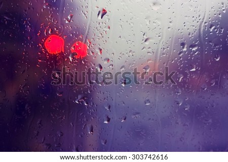 Glass of the window with raindrops and red light signal. Location Edinburgh, Scotland (picture taken from the bus).