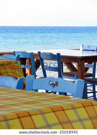 Blue wooden chairs in the traditional cafe by the sea