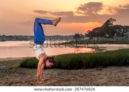 Yoga Model Doing Handstand On Beach at Sunset