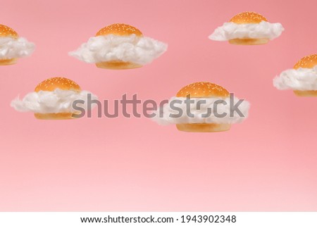 White clouds inside burger buns floating against pink sky background. Surreal fast food hamburger group concept. 2021 minimal abstract summer healthy low calorie diet food idea.