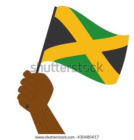 Hand holding and raising the national flag of Jamaica