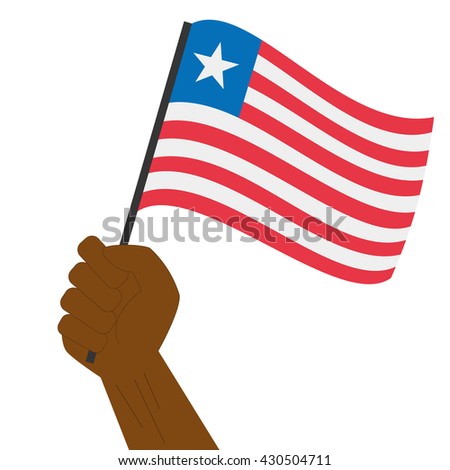 Hand holding and raising the national flag of Liberia