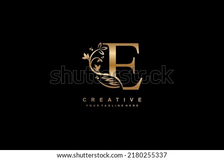 gold letter E logo design with flower, leaf and feather decoration in beautiful and elegant style. monogram E. typography E. initials E logo. suitable for, business, wedding, boutique, company, etc