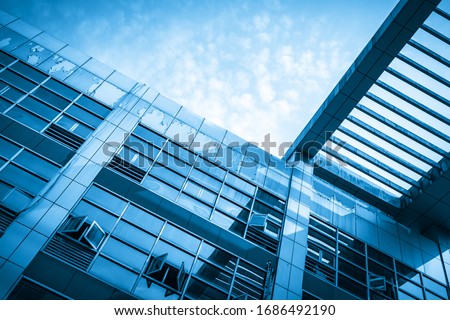 Looking up at the glass facade of a skyscraper